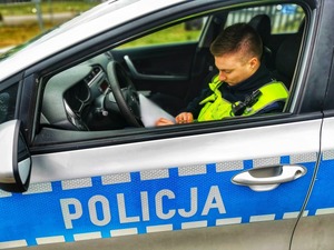 policjant z ruchu drogowego w radiowozie