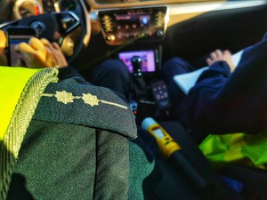 policjanci w radiowozie rozpisują notatnik